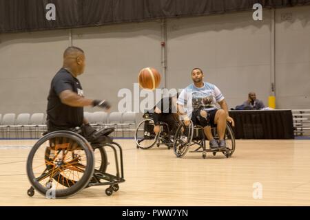 U.S. Army Sgt. Christopher McGinnis, from Bethesda, Maryland, catches the ball during wheelchair basketball drills for the welcome brief for the 2017 Department of Defense Warrior Games at Chicago, Ill., June 29, 2017. The DOD Warrior Games are an annual event allowing wounded, ill and injured service members and veterans in Paralympic-style sports including archery, cycling, field, shooting, sitting volleyball, swimming, track and wheelchair basketball. Stock Photo