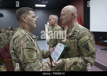 Maj. Gen. Flem Walker, commanding general of the 1st Sustainment Command (Theater), left, presents the Legion of Merit to Command Sgt. Maj. David Wilson, CSM of the 3rd Medical Command (Deployment Support) – Operational Command Post, Detachment 19, during their Change of Command and Transfer of Authority ceremony to the 3rd MEDCOM, Detachment 20, at Camp As Sayliyah, Qatar, June 30, 2017. Stock Photo