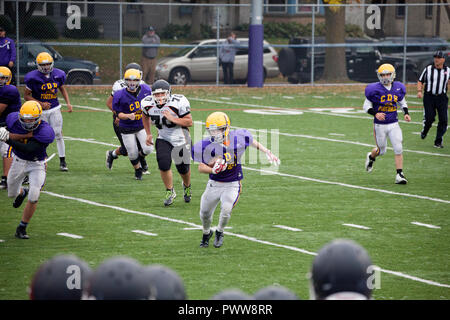 Cretin-Durham Hall High School football back running with ball while teammates block & White Bear player tries to catch him. St Paul Minnesota MN USA Stock Photo