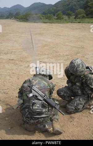 U.S. Marines assigned to India Company, 3rd battalion, 8th Marine Regiment, forward deployed to the 3rd Marine Division, as part of the forward Unit Deployment Program, and Republic of Korea Marines (ROK) participate in the Korean Marine Exchange Program (KMEP) 17-11 at Twin Bridges training area, South Korea, June 20, 2017. KMEP is an annual bilateral training exercise that increases interoperability and combined capabilities of the ROK and U.S. Marine Corps Forces. Stock Photo