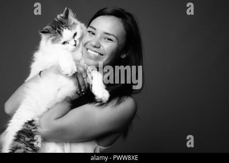 Young Asian woman against gray background in black and white Stock Photo
