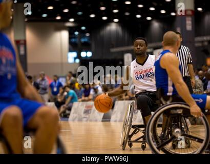 U.S. Army veteran Charles Hightower, from Arlington, Texas, dribbles the ball for the wheelchair basketball competition for the 2017 Department of Defense Warrior Games at Chicago, Ill., July 1, 2017. The DOD Warrior Games are an adaptive sports competition for wounded, ill and injured service members and veterans. Approximately 265 athletes representing teams from the Army, Marine Corps, Navy, Air Force, Special Operations Command, United Kingdom Armed Forces, and the Australian Defence Force will compete June 30 - July 8 in archery, cycling, track, field, shooting, sitting volleyball, swimmi Stock Photo