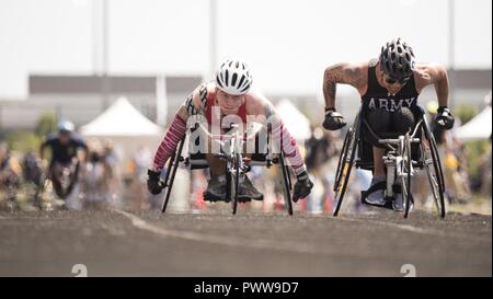 Marine Corps Corp. Dakota Q. Boyer, left, races Army veteran Sgt. Jhoonar Barrera in wheelchair racing at the track competition during the 2017 Department of Defense ) Warrior Games at Lane Tech in Chicago, Ill., July 2, 2017. The DoD Warrior Games are an annual event allowing wounded, ill and injured service members and veterans to compete in Paralympic-style sports including archery, cycling, field, shooting, sitting volleyball, swimming, track and wheelchair basketball. Stock Photo