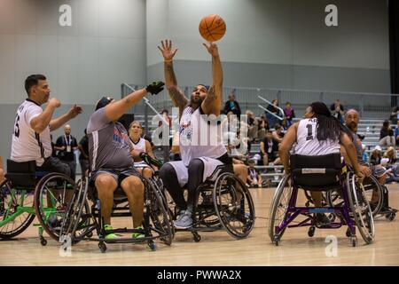 U.S. Army Sgt Christopher McGinnis, from Bethesda, Md., practices for the wheelchair basketball competition for the 2017 Department of Defense Warrior Games at Chicago, Ill., June 30, 2017. The DOD Warrior Games are an annual event allowing wounded, ill and injured service members and veterans in Paralympic-style sports including archery, cycling, field, shooting, sitting volleyball, swimming, track and wheelchair basketball. Stock Photo