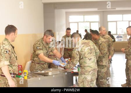 Battle Group Poland U.K. soldiers sell concessions to battle group soldiers prior to an advance screening of the new Spiderman Homecoming movie exclusively for the soldiers at Bemowo Piskie Training Area June 30.  The unique, multinational formation of U.S., U.K. and Romanian soldiers serve with the Polish 15th Mechanized Brigade as a deterrence force in northeast Poland in support of NATO’s Enhanced Forward Presence. Stock Photo