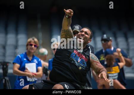 U.S. Army Sgt. Christopher McGinnis throws in the seated shot put event for the 2017 Department of Defense Warrior Games at Chicago, Ill., July 5, 2017. The DOD Warrior Games are an annual event allowing wounded, ill and injured service members and veterans in Paralympic-style sports including archery, cycling, field, shooting, sitting volleyball, swimming, track and wheelchair basketball. Stock Photo