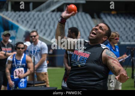 U.S. Army Sgt. Christopher McGinnis throws in the seated shot put event for the 2017 Department of Defense Warrior Games at Chicago, Ill., July 5, 2017. The DOD Warrior Games are an annual event allowing wounded, ill and injured service members and veterans in Paralympic-style sports including archery, cycling, field, shooting, sitting volleyball, swimming, track and wheelchair basketball. Stock Photo