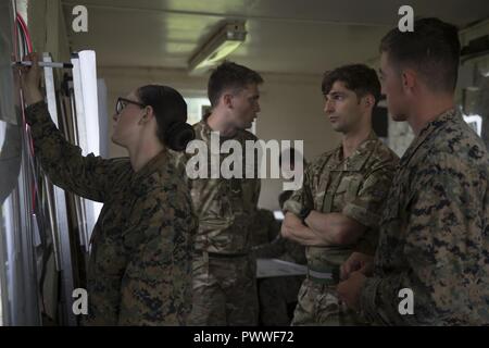 U.S. Marines and British soldiers plan a course of action for simulated troop movement during Exercise Phoenix Odyssey 17 at Garelochhead Training Camp, Scotland, June 21, 2017. Phoenix Odyssey, an ongoing two-week evolution, allows Marines, Sailors and British soldiers to share with one another intelligence operations capabilities, which expands our capabilities to work as NATO allies in the event of real-world operations. The Marines and Sailors participating are assigned to 2nd Intelligence Battalion, II Marine Expeditionary Force. Stock Photo