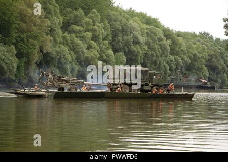 Soldiers assigned to Field Artillery Squadron, 2d Cavalry Regiment, U.S. Army have their Light Medium Tactical Vehicle and M777 howitzer transported over the Mosoni-Duna River in Gyor, Hungary by a PMP Floating Bridge during exercise Szentes Axe 17 July 4, 2017. The bridge is operated by the engineers from 37th Engineer Regiment, Hungarian Defense Force and 837th Brigade Engineer Battalion, U.S. Army National Guard from Wooster, Ohio. The Hungarian national exercise takes place June 26-July 7 to enable Saber Guardian 17 by conducting tactical bridging and water crossing operations for 2CR free Stock Photo