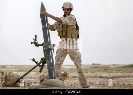 An Iraqi army soldier loads a 120mm mortar during indirect fire training led by the Portuguese army at the Besmaya Range Complex July 5, 2017. This training is part of the overall Combined Joint Task Force – Operation Inherent Resolve building partner capacity mission which focuses on training and improving the capability of partnered forces fighting ISIS. CJTF-OIR is the global Coalition to defeat ISIS in Iraq and Syria. Stock Photo