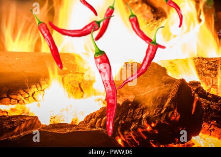 a few pieces of red chili peppers on background with fire Stock Photo