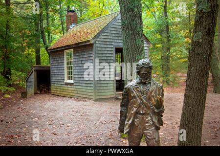 Concord, MA--Oct 11, 2018; statue of the American writer Henry David Thoreau in front of recreation of the house he lived in at Walden Pond Stock Photo