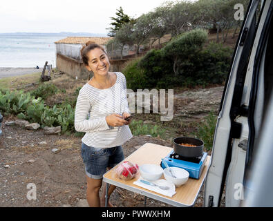 Happy beautiful yong woman traveling by camper van around Europe in Life Inspiration Camper van life Van adventure Road trip and traveling on budget c Stock Photo