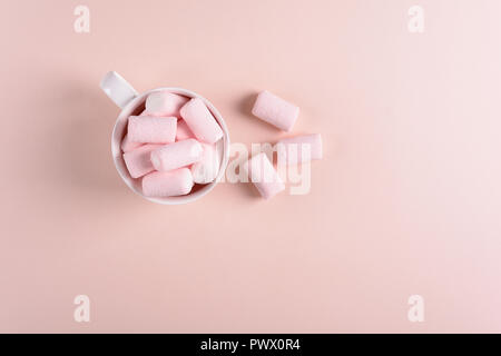 Hot chocolate with marsmallow candies on pink paper background. Top view. Copy space Stock Photo