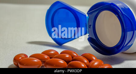 Orange pills and open bottle on a white background Stock Photo