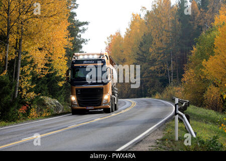 Salo, Finland - October 13, 2018: Volvo FH semi tanker of J. Mettala Ky for bulk transport delivers load on autumnal highway, high beams on briefly. Stock Photo