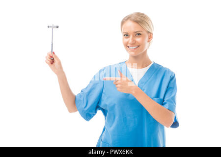 smiling young neurologist pointing at reflex hammer isolated on white Stock Photo