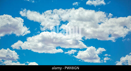 Vibrant blue sky with illuminated puffy clouds Stock Photo