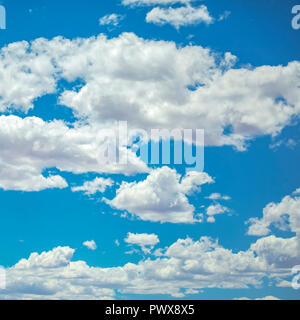 White puffy clouds on a vivid blue sky Stock Photo