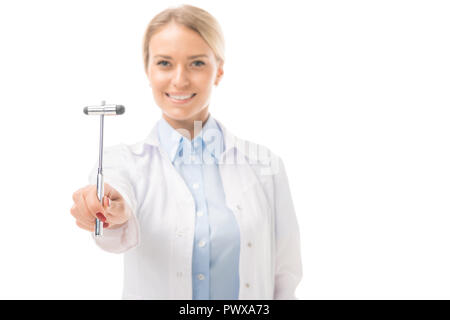 smiling young female neurologist holding reflex hammer and looking at camera isolated on white Stock Photo