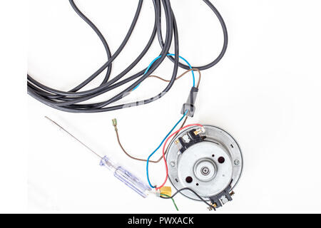Vacuum cleaner motor  with cord and srewdriver on a white background top view Stock Photo