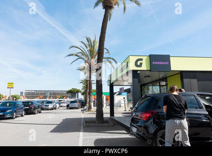 Woman checking over hire car outside Goldcar car hire/rental office at Barcelona El Prat airport. Spain Stock Photo