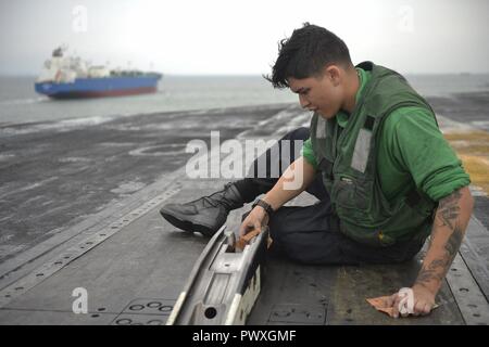 SINGAPORE STRAIT (July 6, 2017) U.S. Navy Aviation Boatswain's Mate (Equipment) Airman Miguel Torres Sandoval, a native of Long Beach, Calif., cleans a catapult system aboard the aircraft carrier USS Nimitz (CVN 68), July 6, 2017, in the Singapore Strait. Nimitz is currently on deployment in the U.S. 7th Fleet area of operations. The U.S. Navy has patrolled the Indo-Asia Pacific routinely for more than 70 years promoting regional peace and security. ( Stock Photo