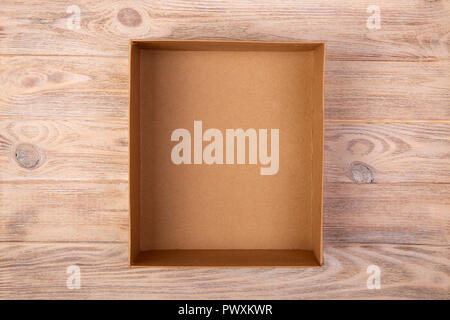 Opened cardboard box on wooden background. top view. Stock Photo