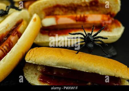 Creepy Halloween hotdog fingers on the black table, party food Stock Photo