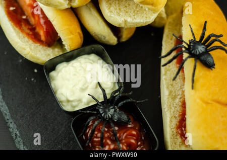 Creepy Halloween hotdog fingers on the black table, party food Stock Photo