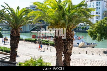 People walking along the bank of the River Guadalquivir in Seville, Spain Stock Photo