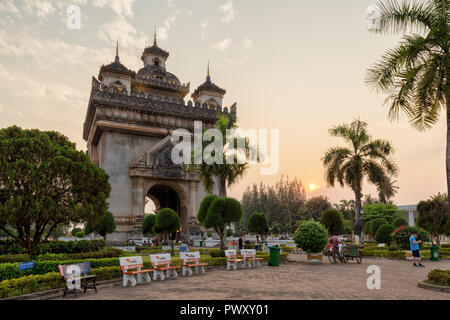 Patuxai (Patuxay), Victory Gate or Gate of Triumph, war monument and few people at the Patuxai Park in Vientiane, Laos, at sunset. Stock Photo