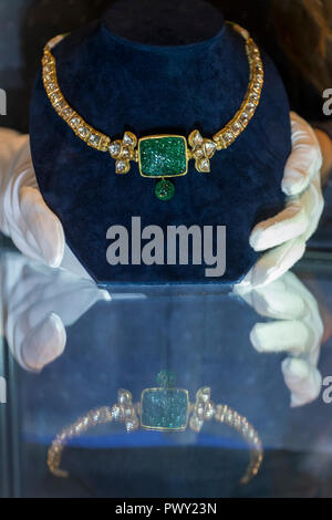 London, UK.  18 October 2018.  A staff member presents 'An emerald and diamond-set necklace', India, late 19th century (Est. GBP15,000 to 20,000). Preview of Bonhams Asian Art Week which features works to be offered in the Islamic and Indian, Modern and Contemporary Middle Eastern art sale on 23 October and Modern and Contemporary South Asian art sale on 24 October.   Credit: Stephen Chung / Alamy Live News Stock Photo