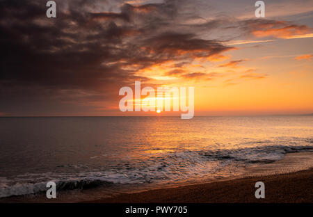 West Bexington, Dorset, UK. 18th October 2018.  UK Weather: The sun sets over Chesil Beach at the end of a glorious and warm sunny day on the Dorset Coast.  Credit: DWR/Alamy Live News Stock Photo