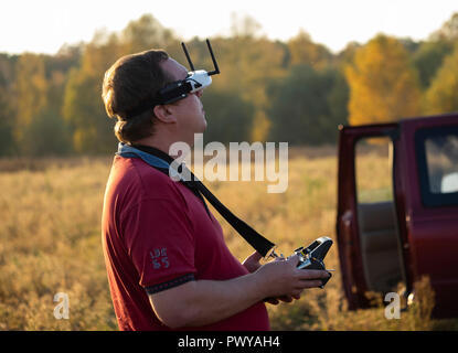Drone pilot seen wearing a first-person view headset. Young man driving a quad-copter using video-goggles Stock Photo