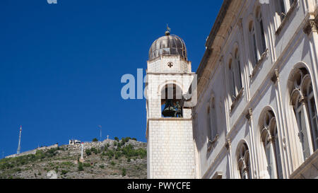 The clock tower of Dubrovnik with the mountain Srd in the background Stock Photo