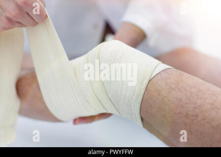 closeup. doctor bandaging a patient's leg Stock Photo