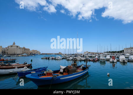 The picturesque fishing port at Trani, historic medieval town in Puglia, southern Italy. Colourful fishing boats in the foreground.