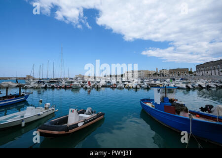 The picturesque fishing port at Trani, historic medieval town in Puglia, southern Italy. Colourful fishing boats in the foreground.