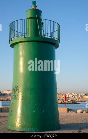 Entrance to the port at Trani, historic medieval town in Puglia, southern Italy. Photo shows the green tower marking the entrance to the harbour. Stock Photo