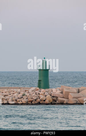 Entrance to the port at Trani, historic medieval town in Puglia, southern Italy. Photo shows the green tower marking the entrance to the harbour. Stock Photo