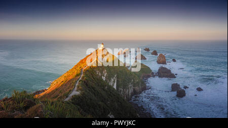 Nugget Point Lighthouse is located on the southeast coast of New Zealand and glows beautiful in the evening light. Stock Photo