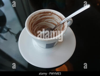 Empty Coffee Cup with a Spoon on a Glass Table at a Hotel Stock Photo