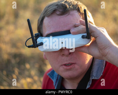 Drone pilot wearing first-person view headset. Young man driving a quad-copter using video-goggles Stock Photo