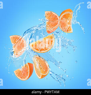 orange slices in water splash on a blue background. Stock Photo