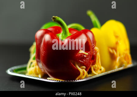 color stuffed peppers with scary cutout faces, halloween party food, fun Stock Photo