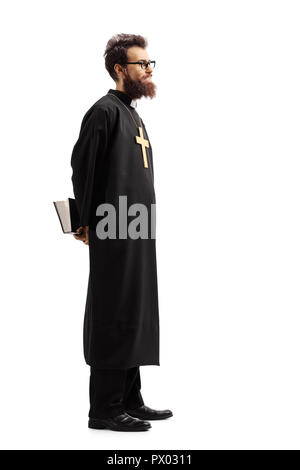 Full length profile shot of a priest with a bible waiting in line isolated on white background Stock Photo