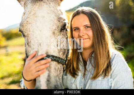 A Beautiful teen girl on the farm with her horse. Stock Photo