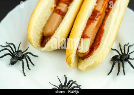 Creepy Halloween hotdog fingers on the black table, party food Stock Photo