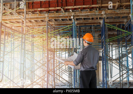 Engineer with blueprint in building construction site Stock Photo